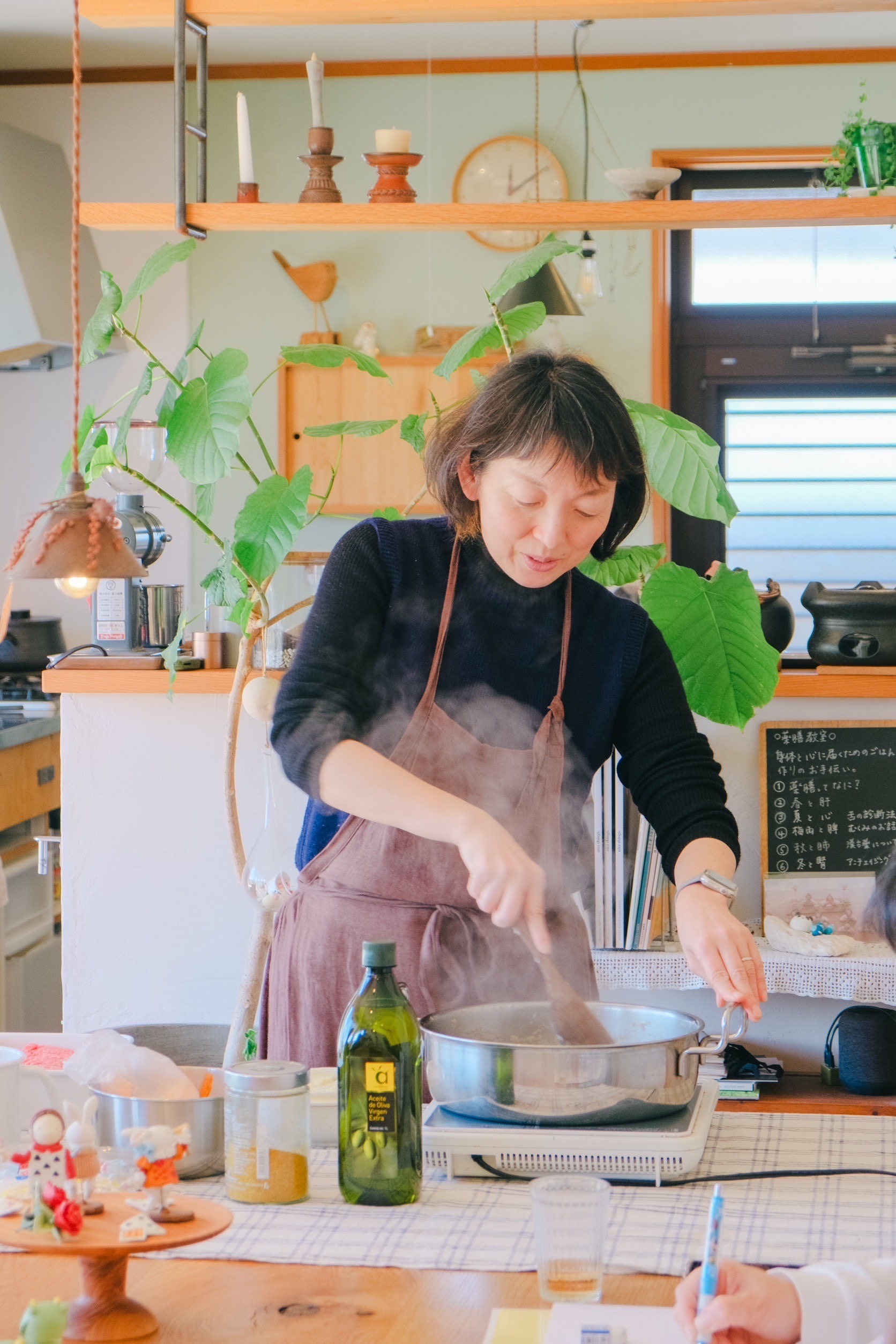 明るい店内で料理を仕立てる、薬膳料理教室の講師